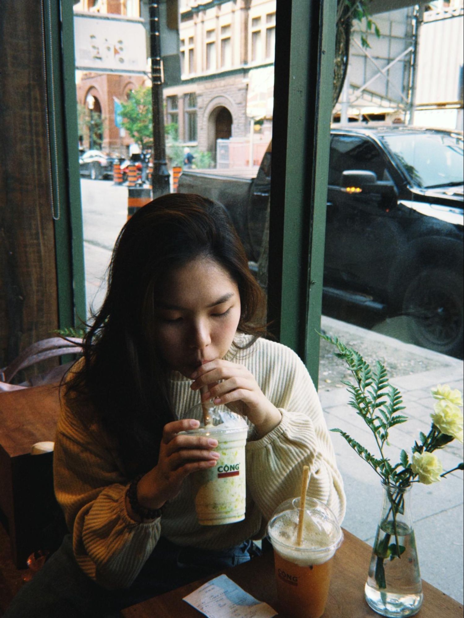 Student in a coffee shop drinking from a straw