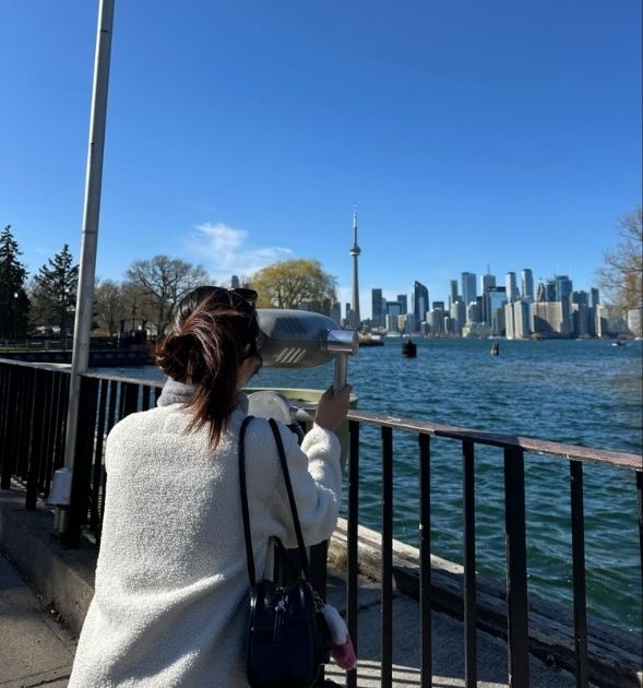 student using binoculars to view the skyline of toronto