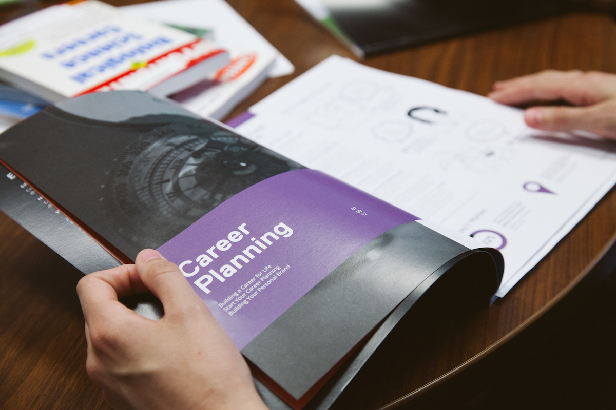 A student is opening the Career Planning brochure.