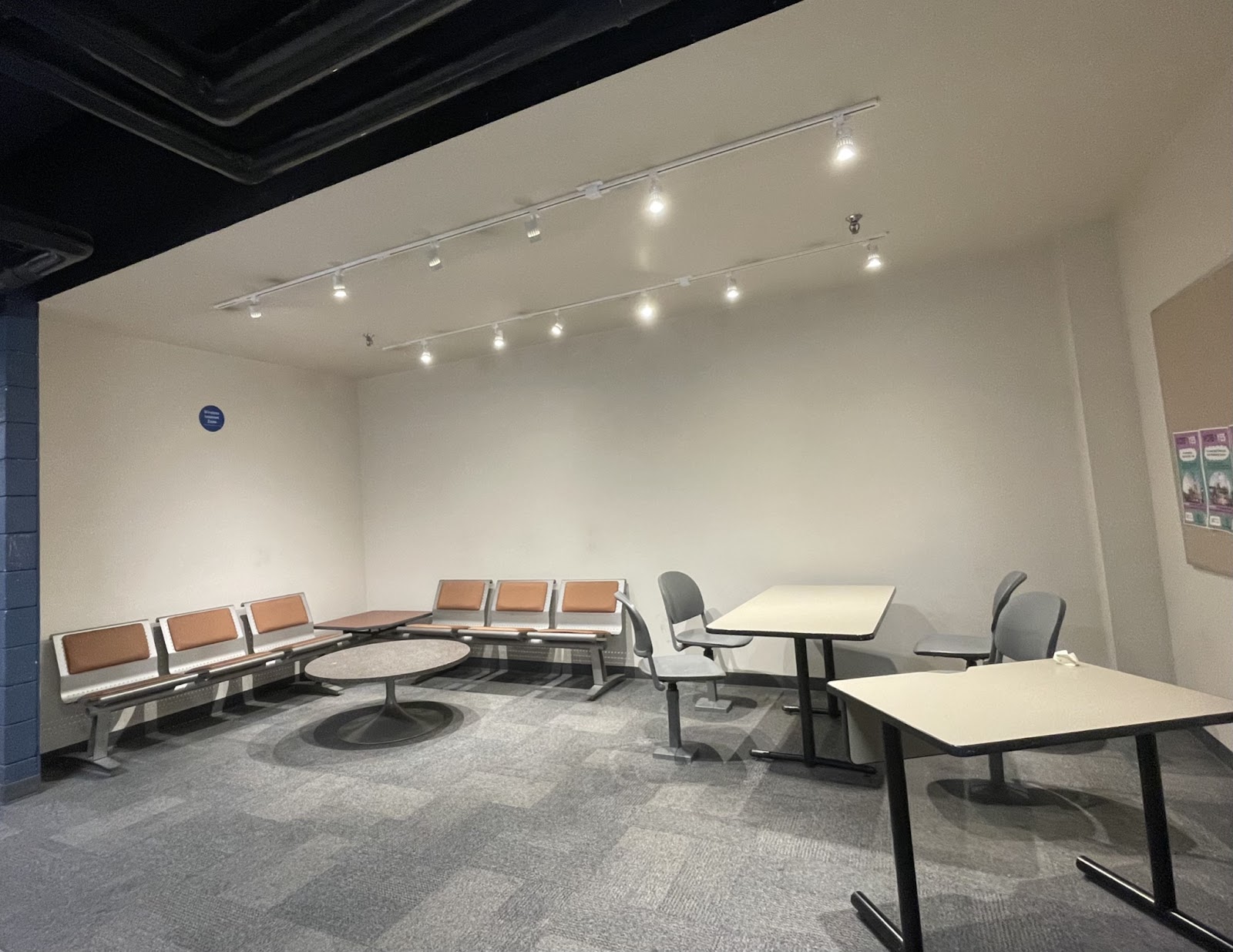 An empty study area with tables and chairs on the first floor of Eric Palin Hall 