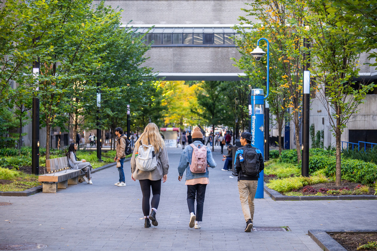 Three students walking on TMU campus. 