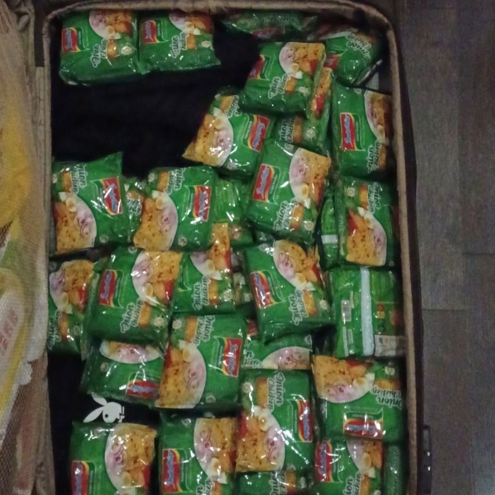 A suitcase filled with packets of instant noodles.