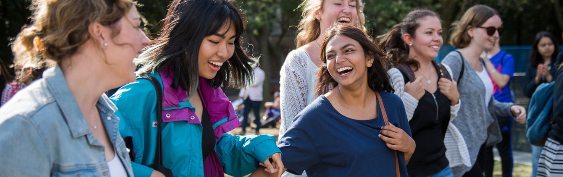 A group of international female students laugh as they walk through the Quad during the International Students Welcome Event.