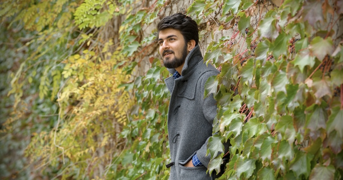 President's Entrance Scholarship recipient Abhi Raheja from India, standing in the Quad against a wall of ivy.