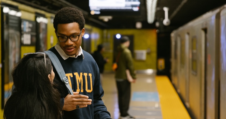 Student standing on the platform of TMU Station as he waits for the subway