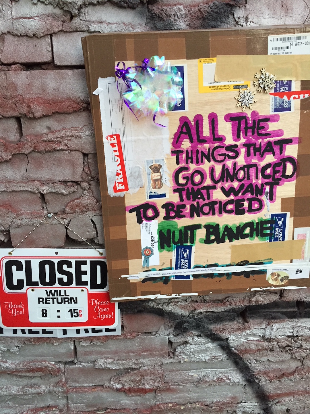 Art installation on a brick wall that reads "closed" and "all the things that go unnoticed that want to be noticed, nuit blanche"