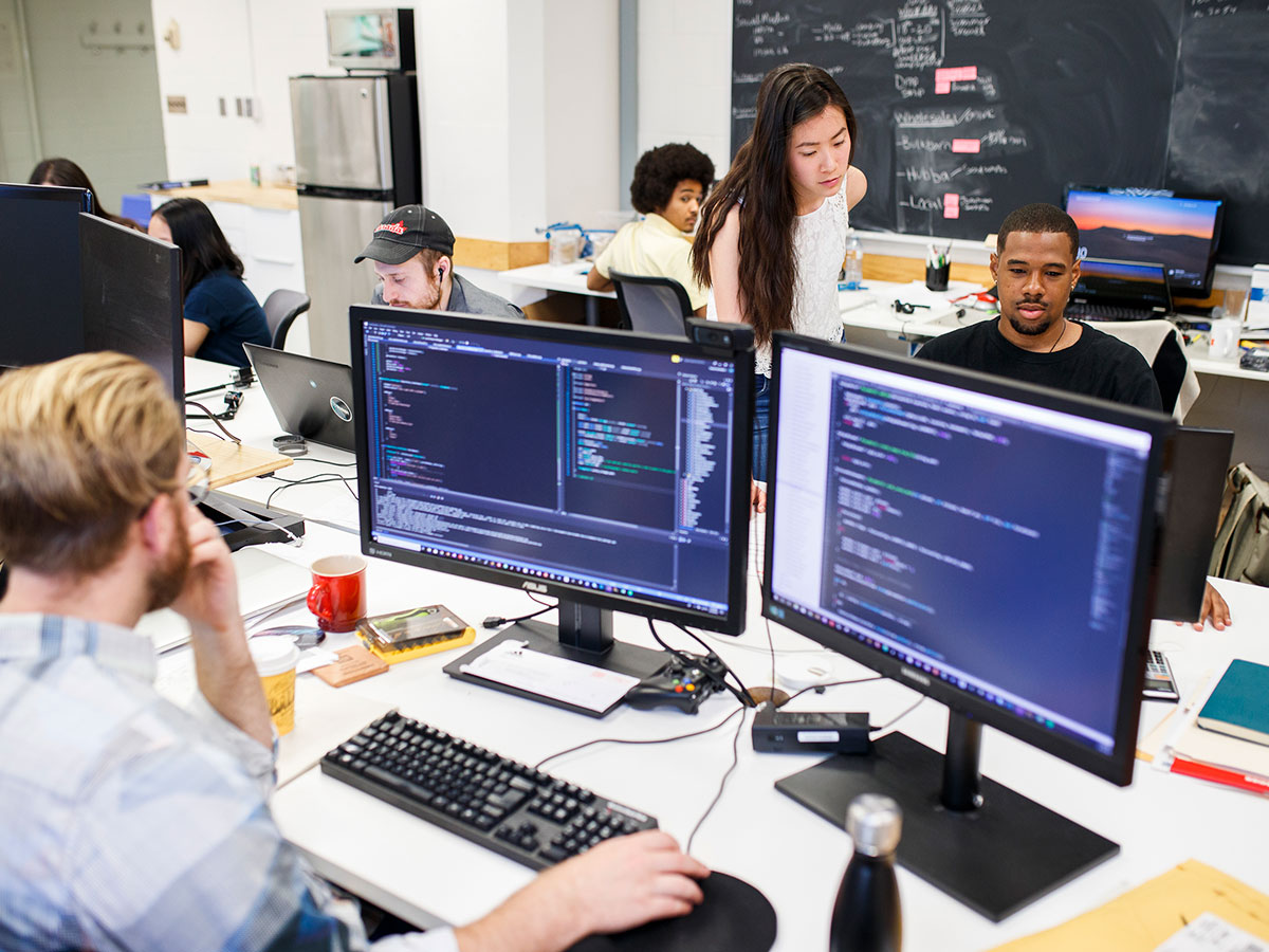 A diverse group of students work in a computer lab.