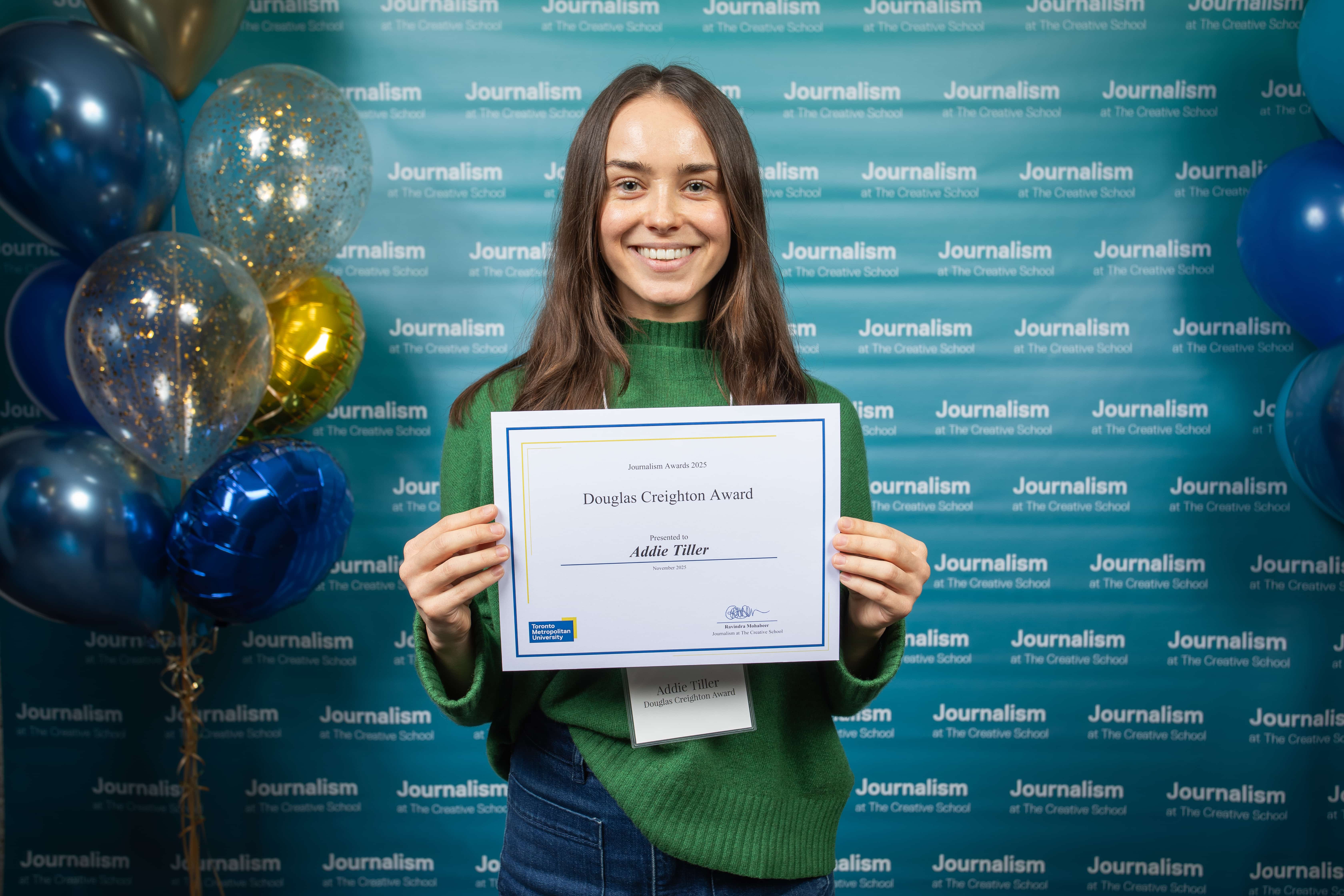 Photo of a person holding their certificate at Journalism School Award ceremony