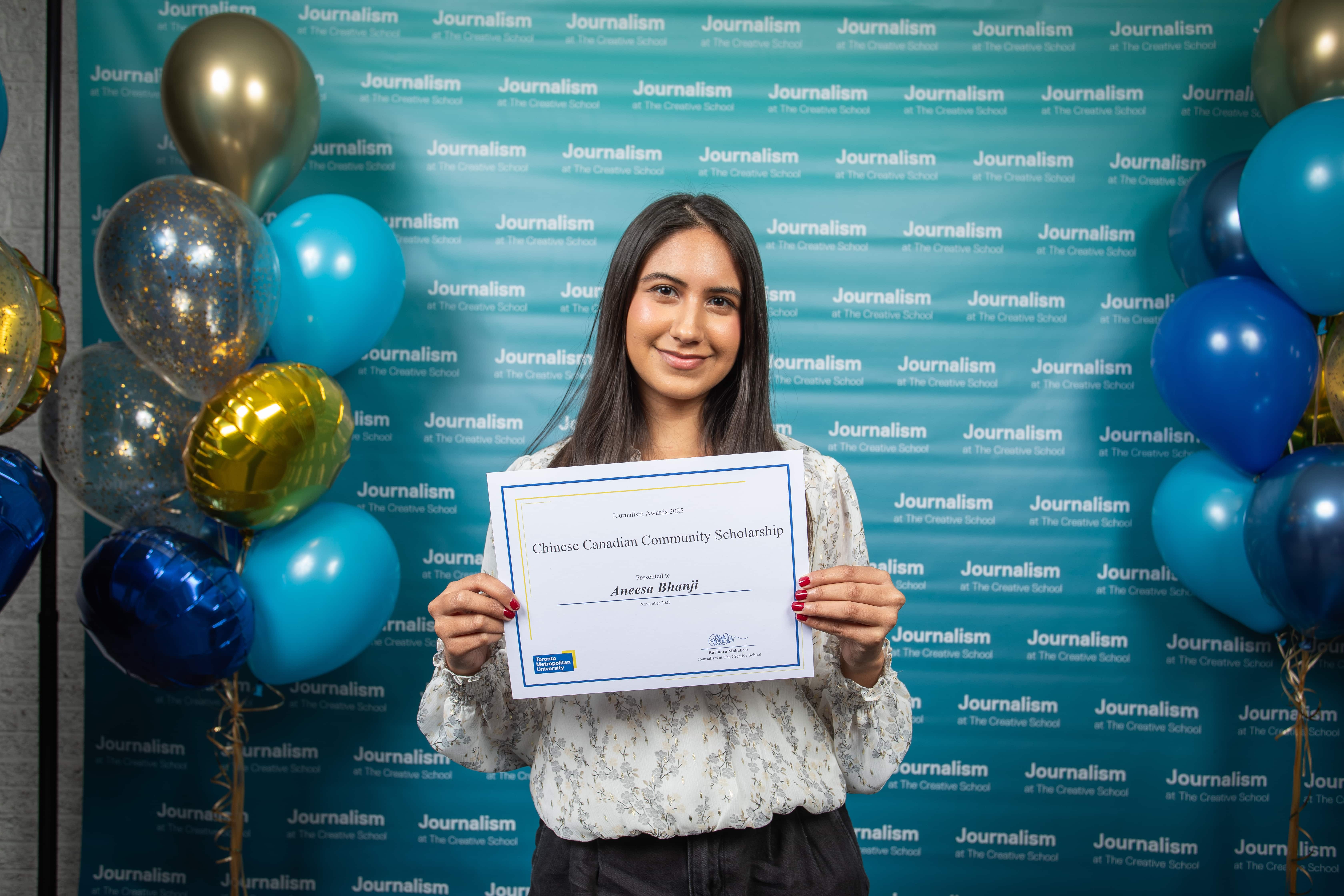 Photo of a person holding their certificate at Journalism School Award ceremony