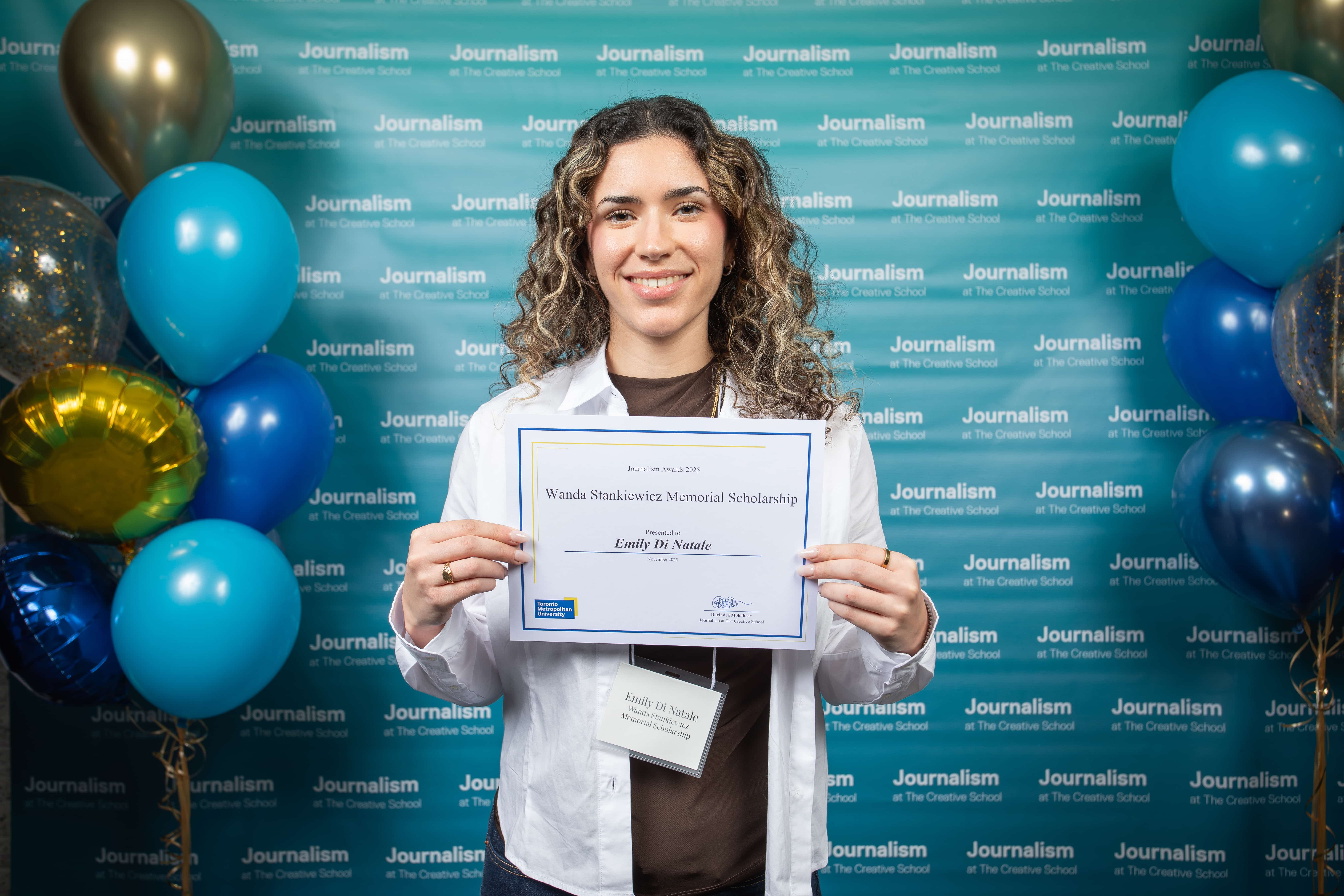 Photo of a person holding their certificate at Journalism School Award ceremony