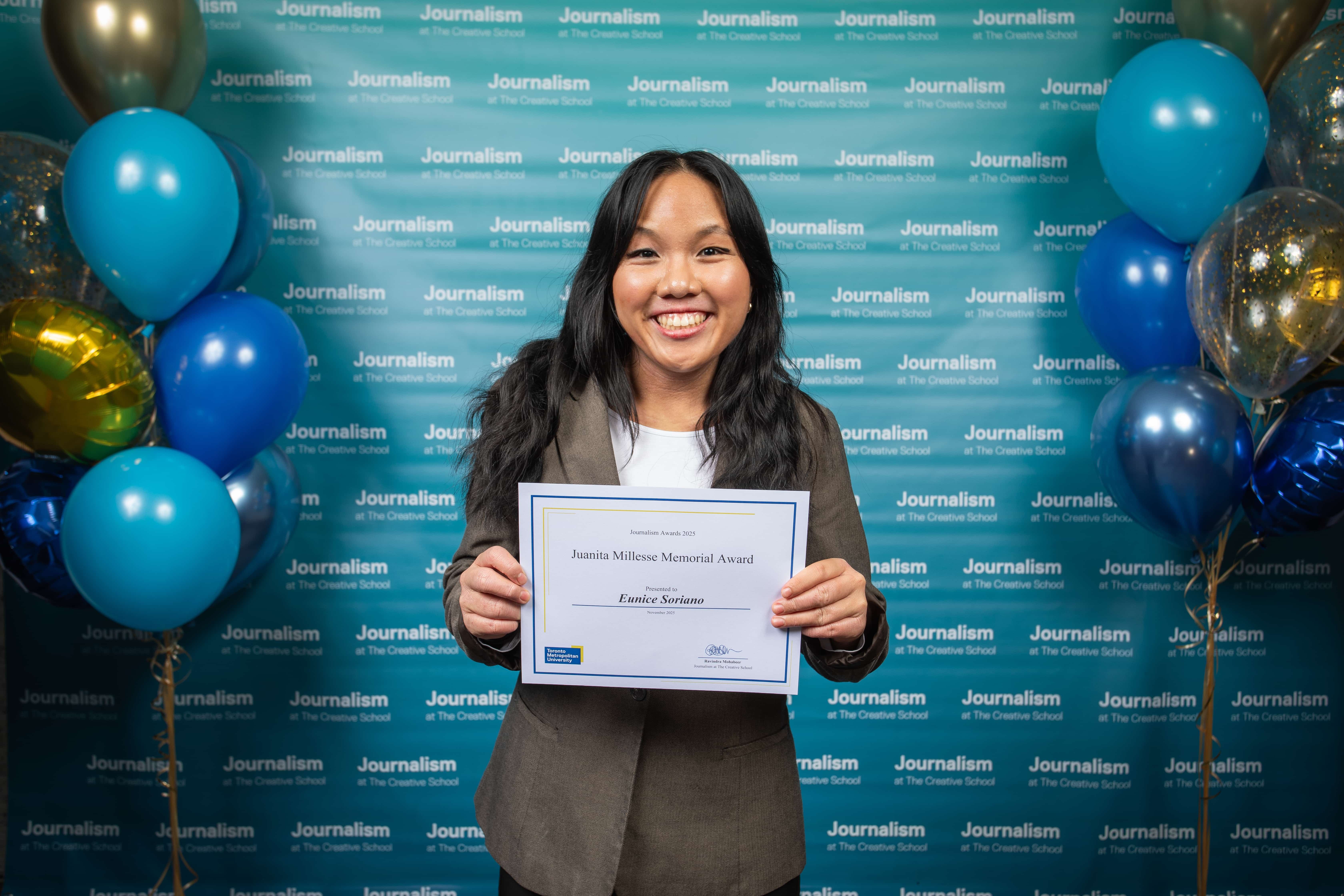 Photo of a person holding their certificate at Journalism School Award ceremony