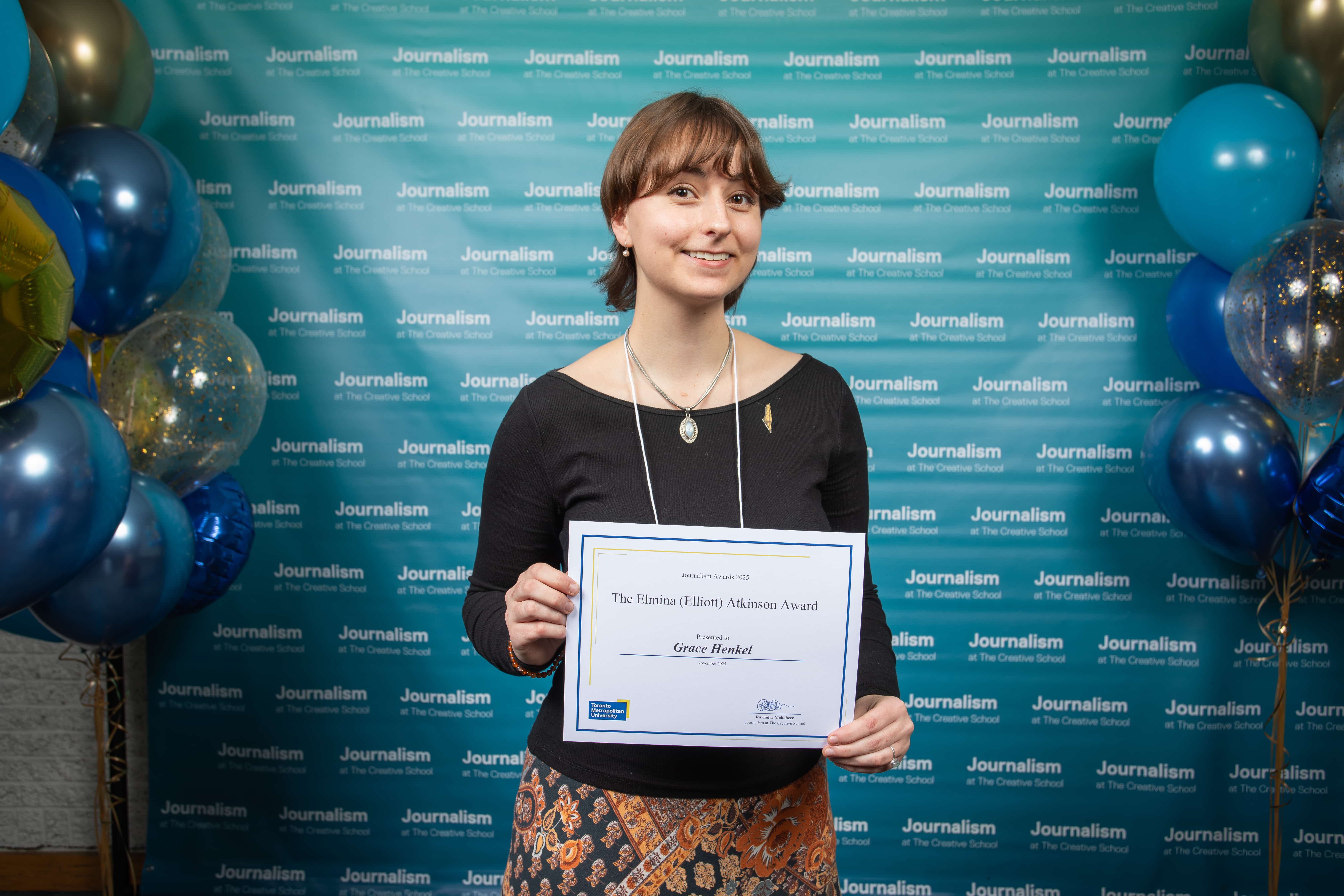 Photo of a person holding their certificate at Journalism School Award ceremony