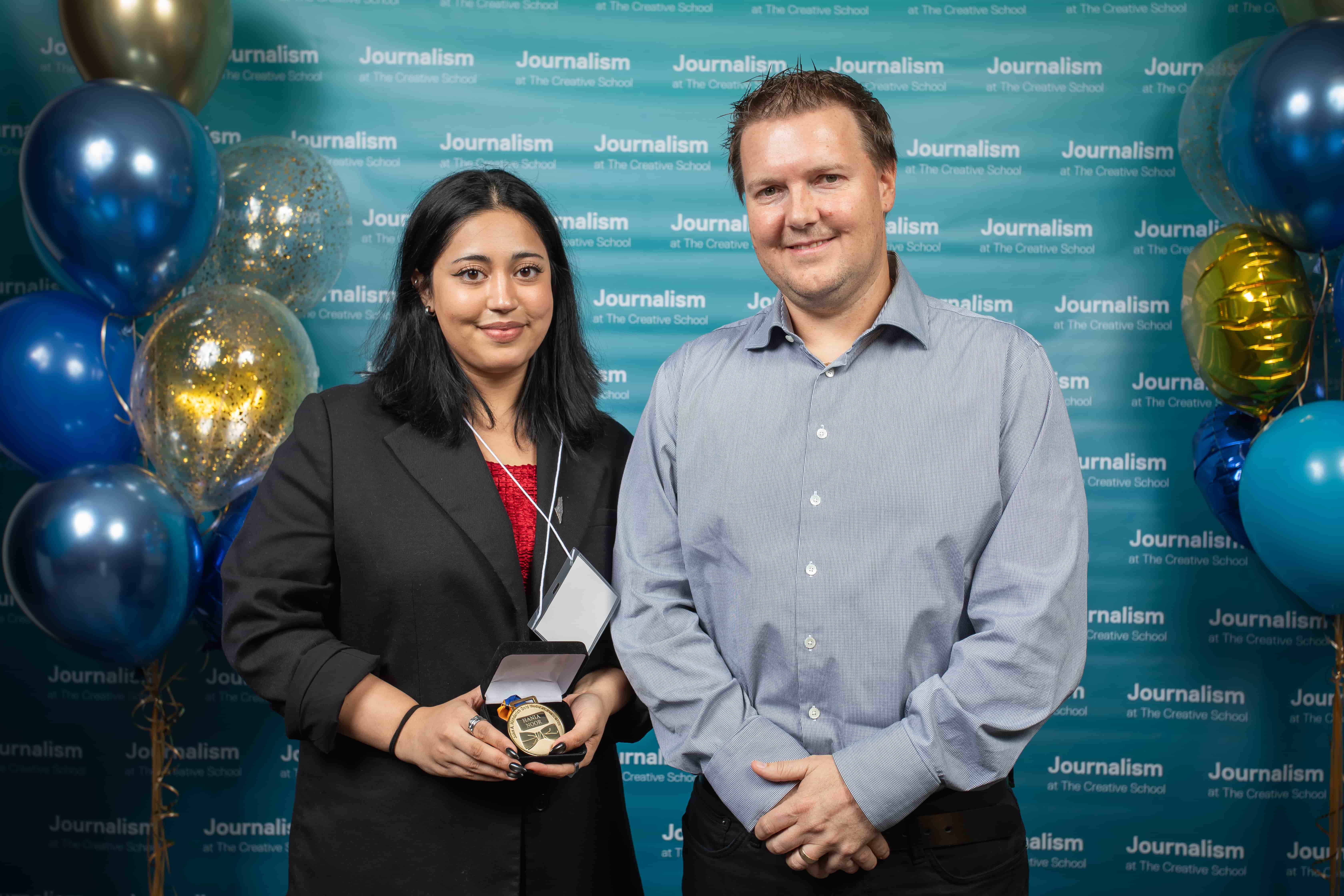Photo of a person holding their certificate at Journalism School Award ceremony with their donor.