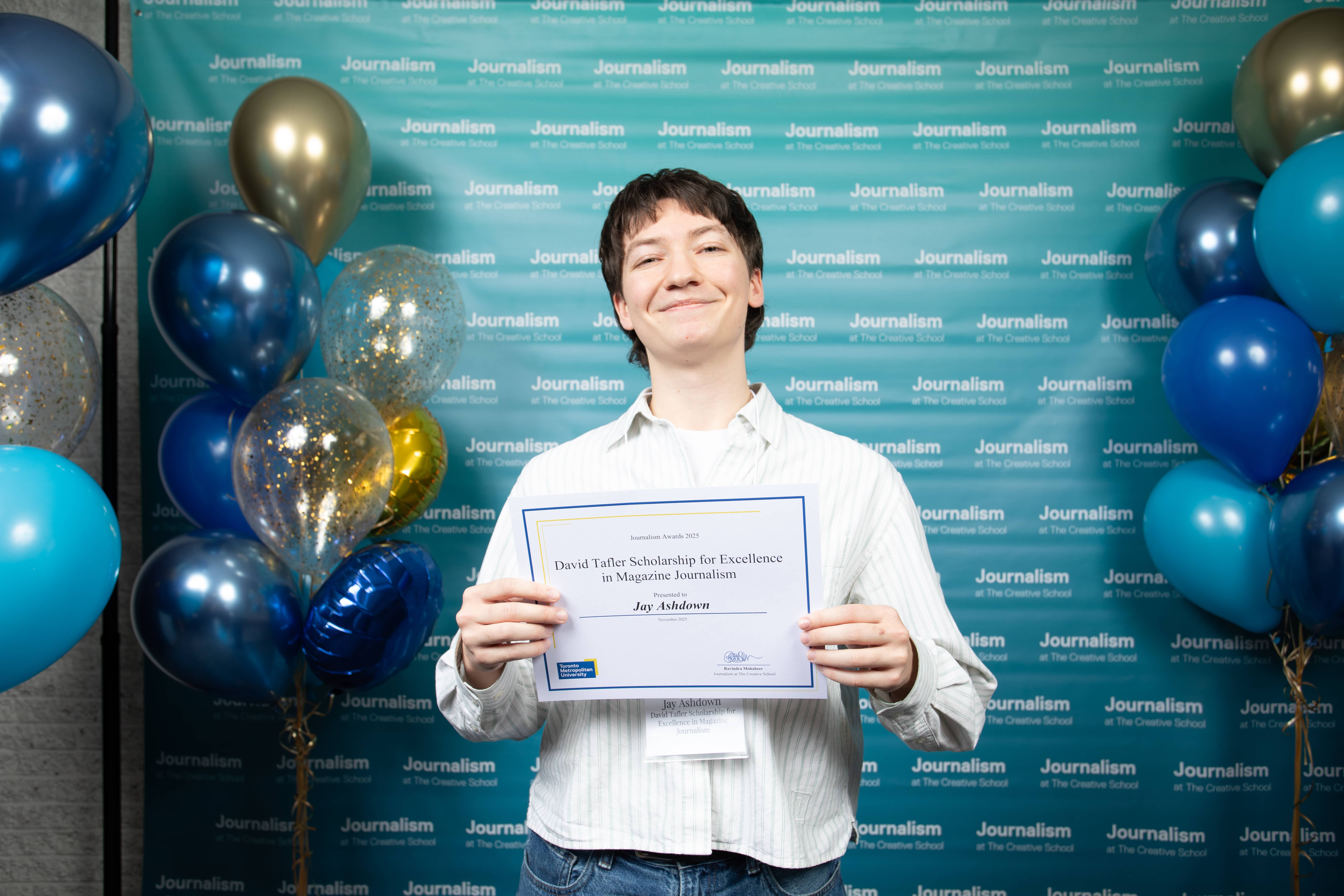 Photo of a person holding their certificate at Journalism School Award ceremony