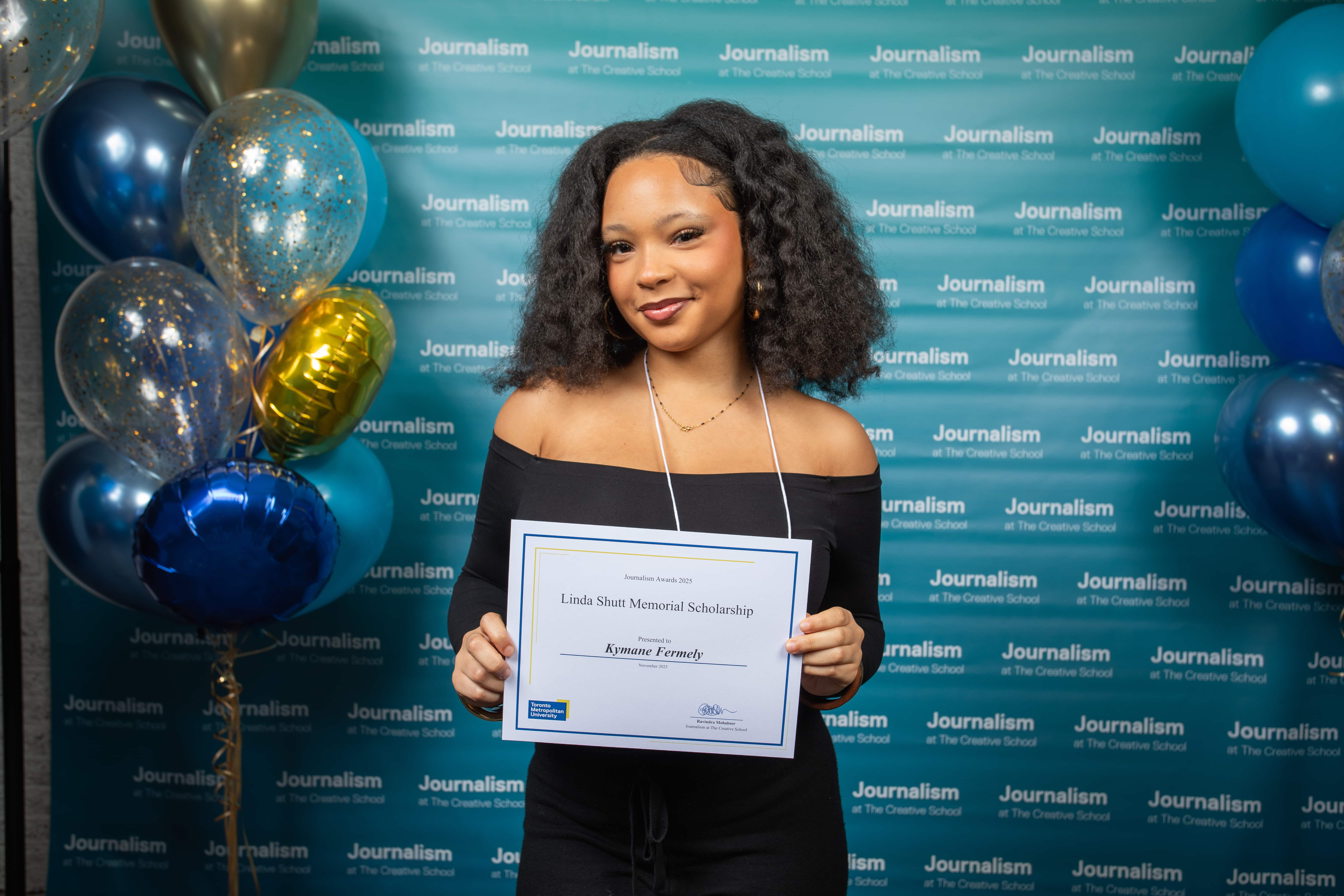 Photo of a person holding their certificate at Journalism School Award ceremony