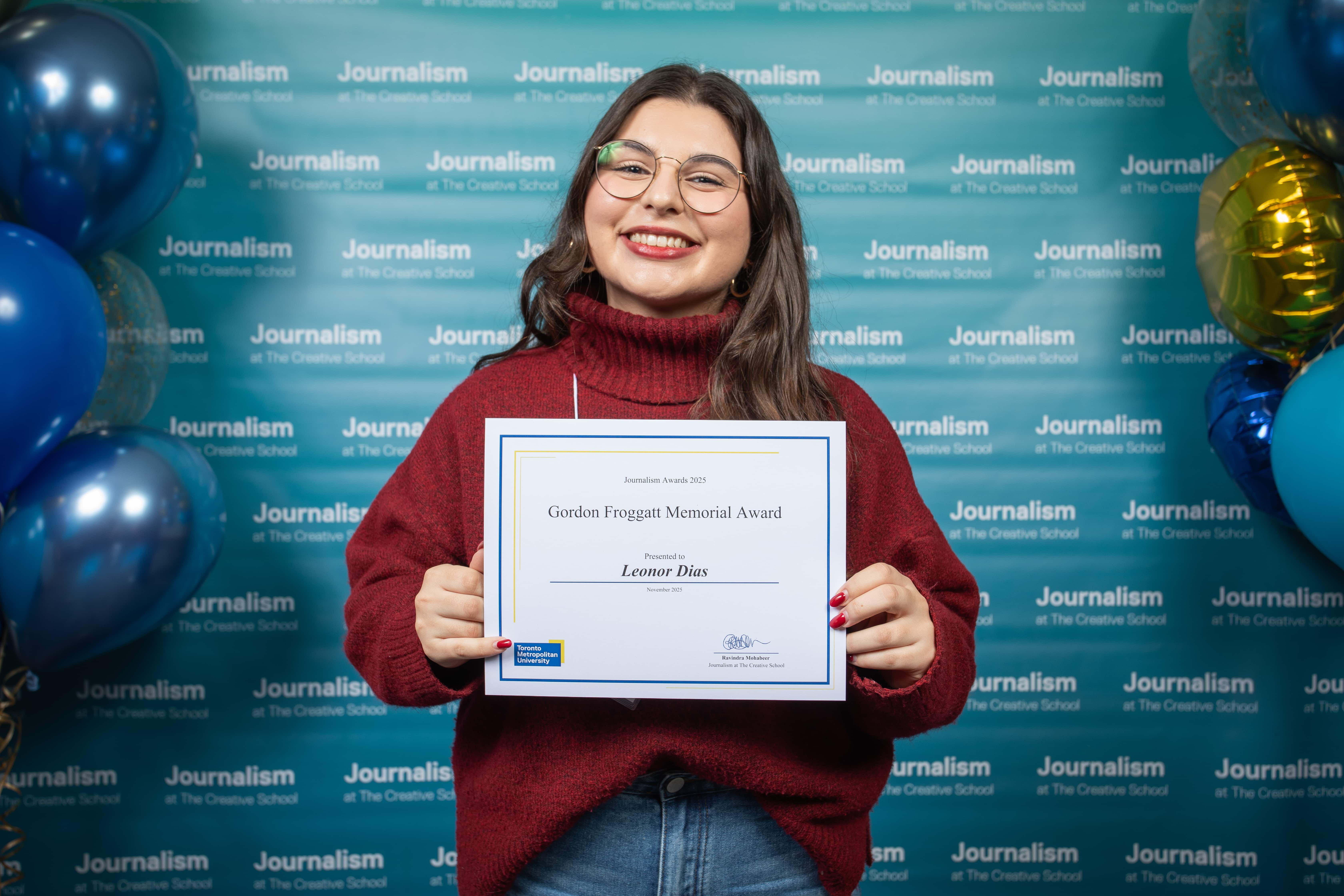 Photo of a person holding their certificate at Journalism School Award ceremony