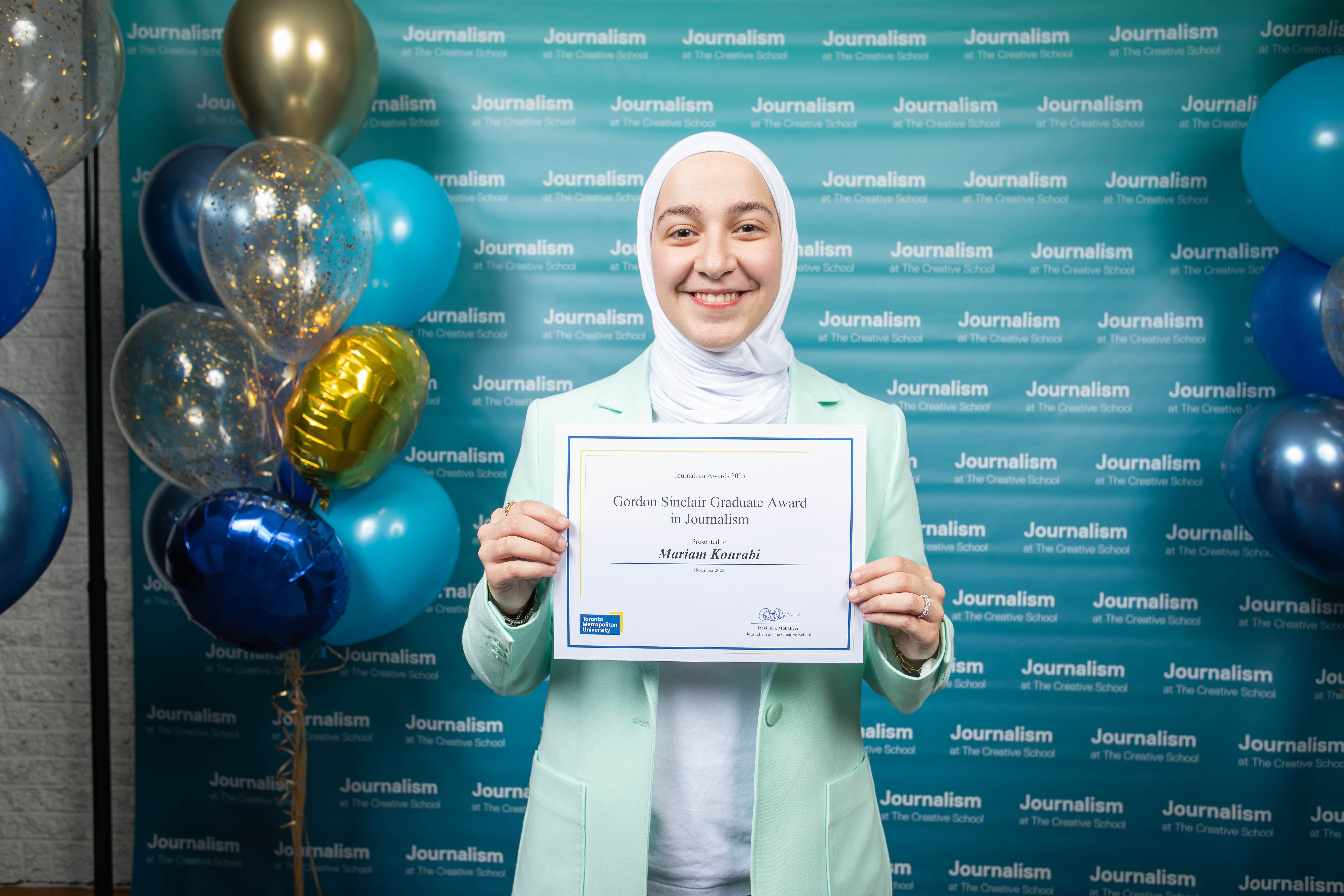 Photo of a person holding their certificate at Journalism School Award ceremony