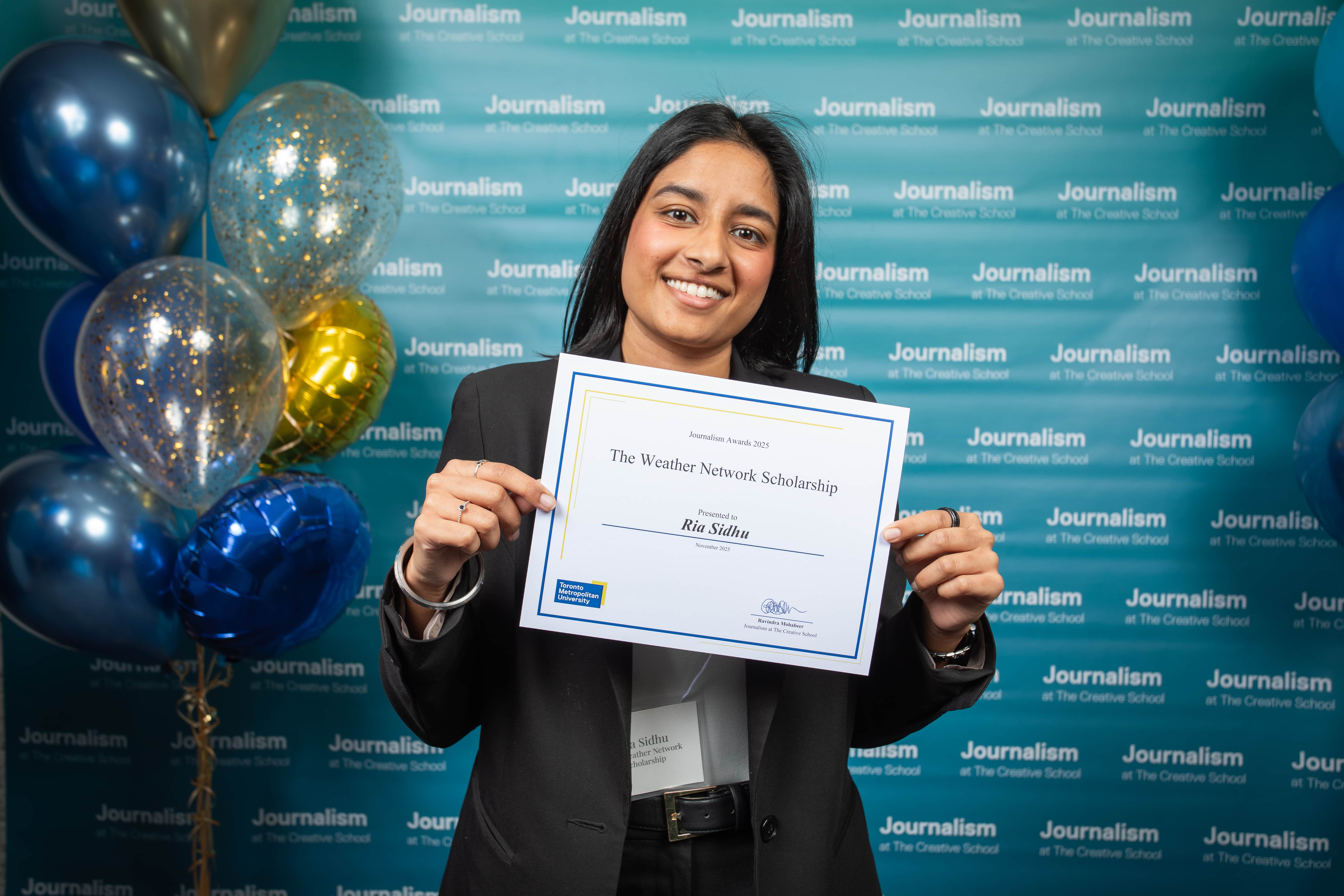 Photo of a person holding their certificate at Journalism School Award ceremony