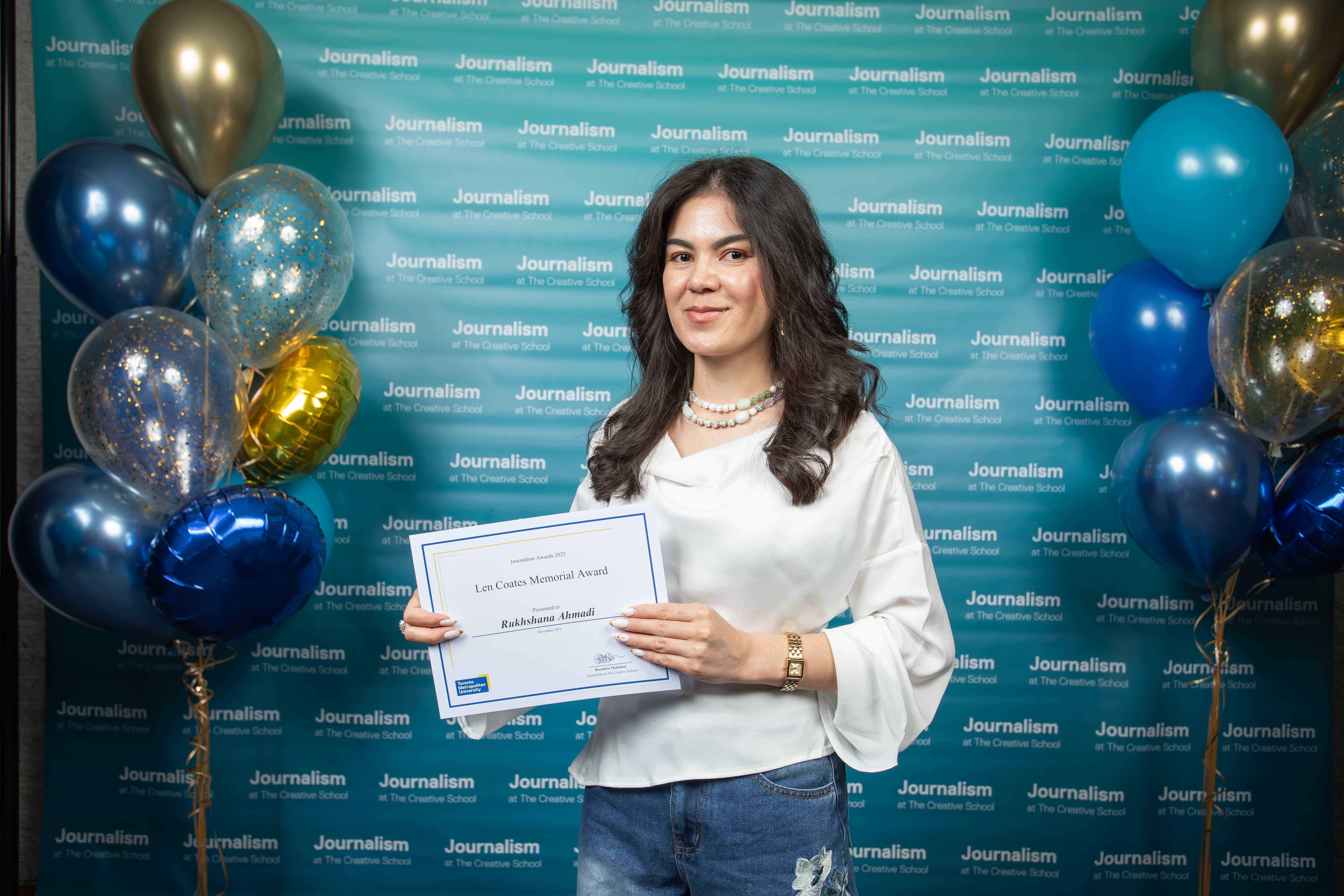 Photo of a person holding their certificate at Journalism School Award ceremony