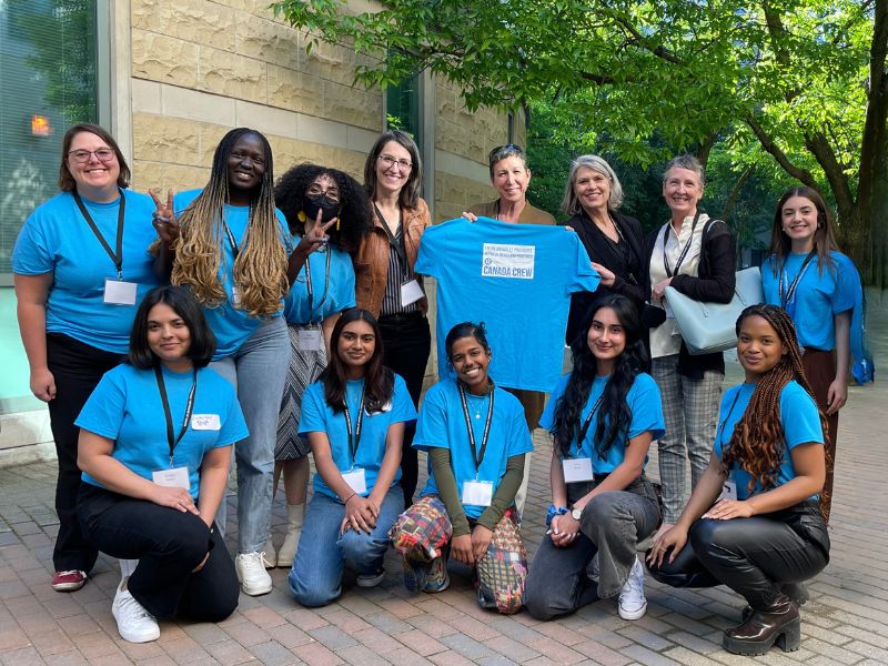 A group of the journalism students who worked at the JRP conference at TMU posing in the bright blue t-shirts they all wore at the conference.