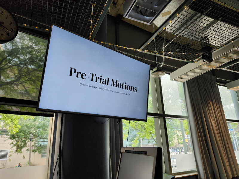 A photo of a TV screen that says "Pre-Trial Motions"