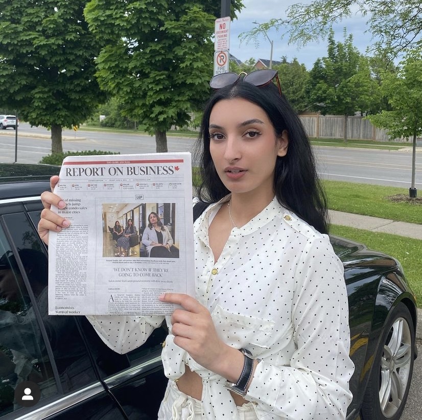 Camilla Bains holding a copy of The Globe and Mail with her article from the L6P project. 