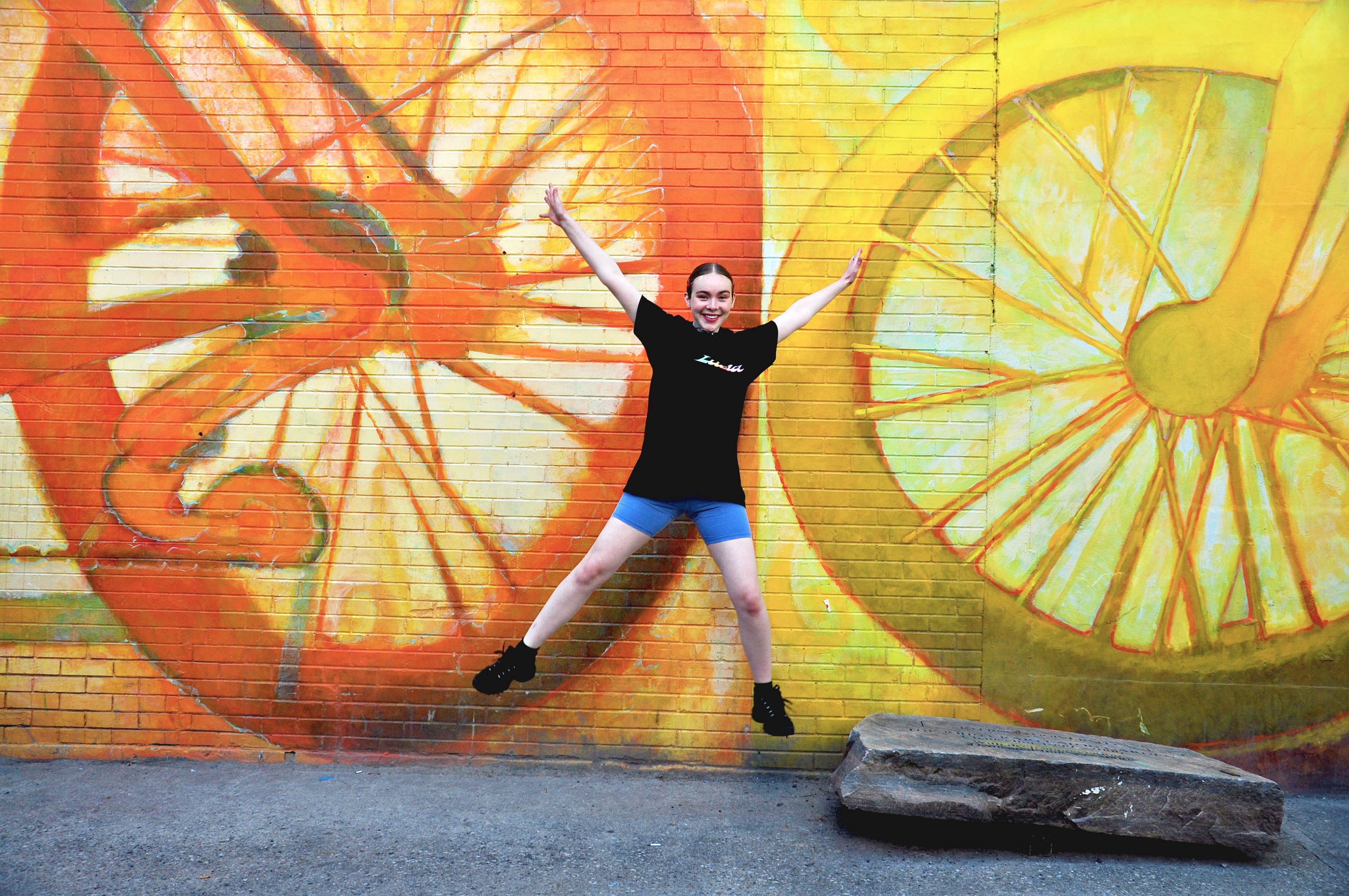 Third-year journalism student Natalie Michie jumps in front of a colourful mural in Downtown Toronto on Sept. 17, 2019.