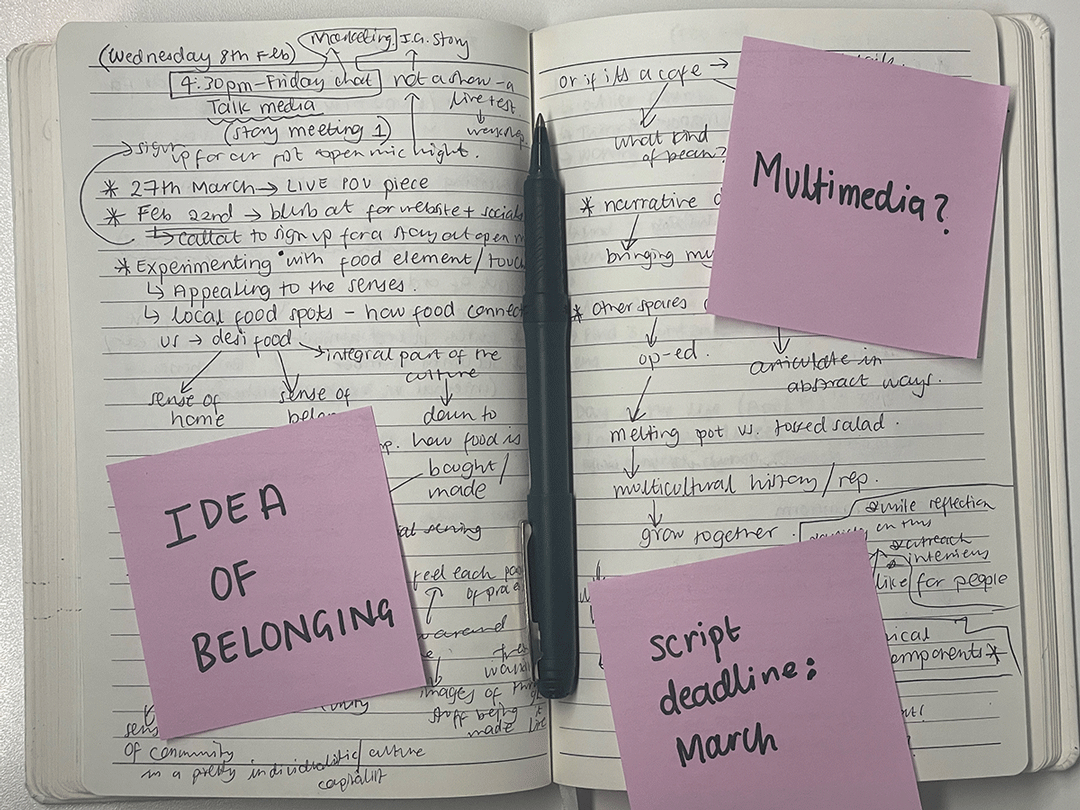 A copy of notes in a notebook with three purple post-it notes from the first brainstorming session