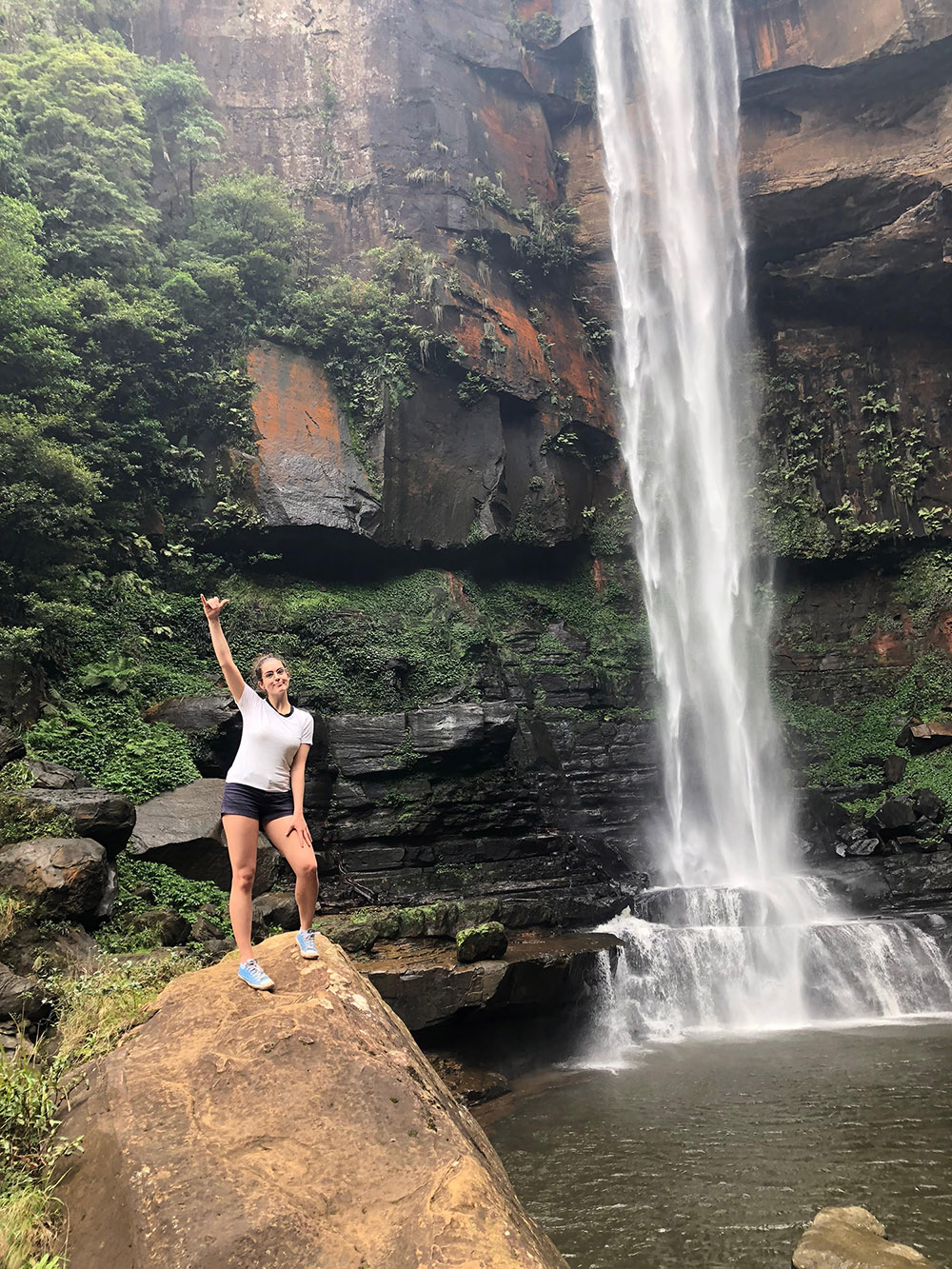 An exchange student in front of a waterfall