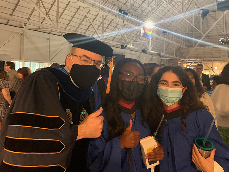 Photo of three people wearing masks and posing together at Convocation.