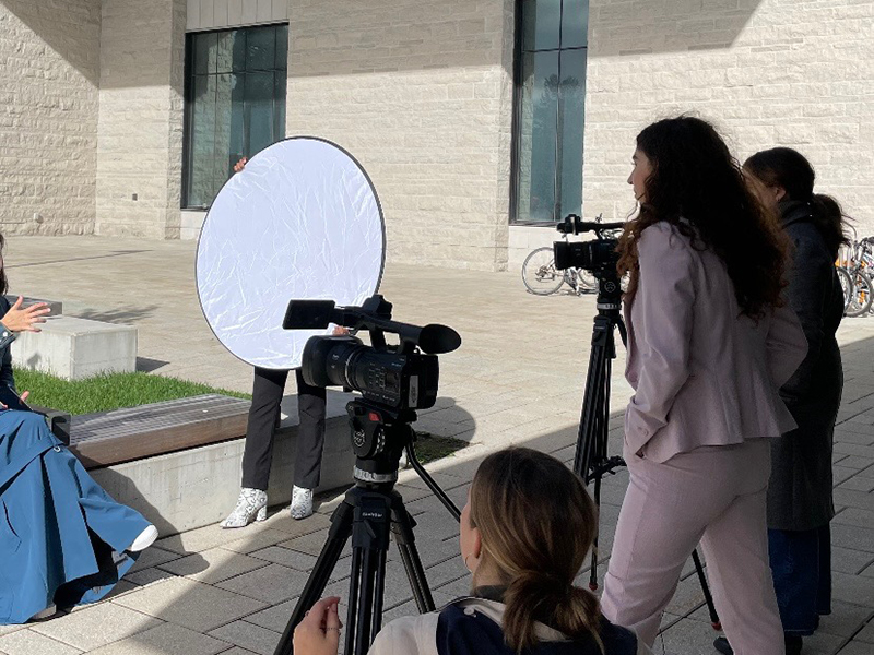 Photo of people filming with camera outside