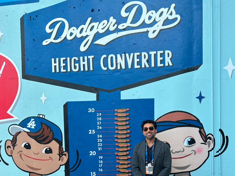 Male alumni stands next to painted wall at Dodgers Stadium.