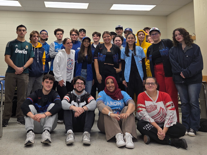 A class photo of students wearing jerseys while smiling at the camera.