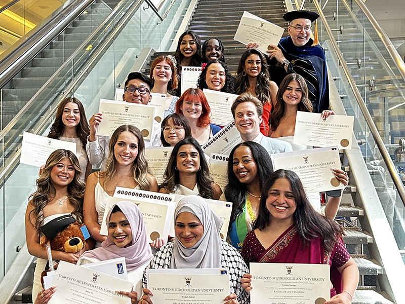 TMU J-school graduates pose with their diplomas after their convocation ceremony at the Mattamy Athletic Centre
