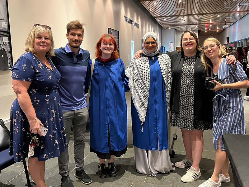 TMU J-school graduates pose with J-school staff after their convocation ceremony at the Mattamy Athletic Centre