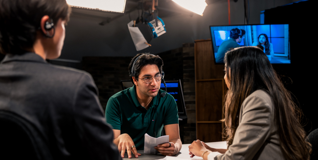 Three students discussing in a Journalism studio