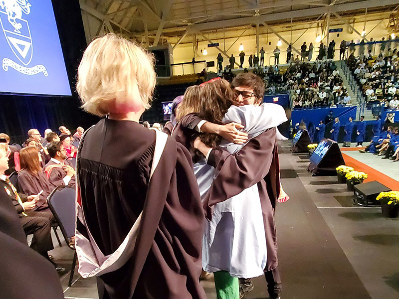 School of Journalism 2023 graduate hugs Sonya Fatah on stage.