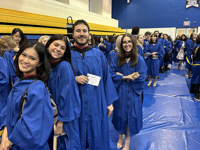 A group of School of Journalism 2023 graduates stand together before the convocation ceremony.