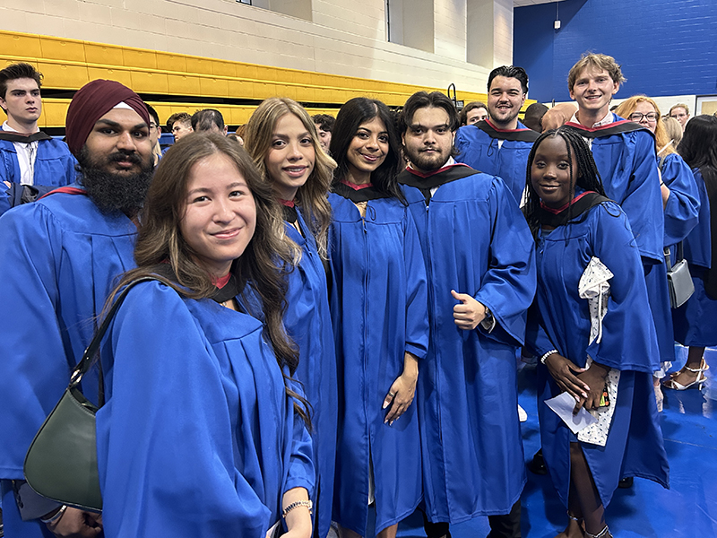 A group of School of Journalism 2023 graduates stand together before the convocation ceremony.