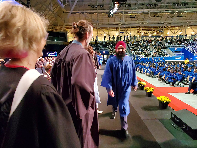 School of Journalism 2023 graduate walks across the stage at convocation.