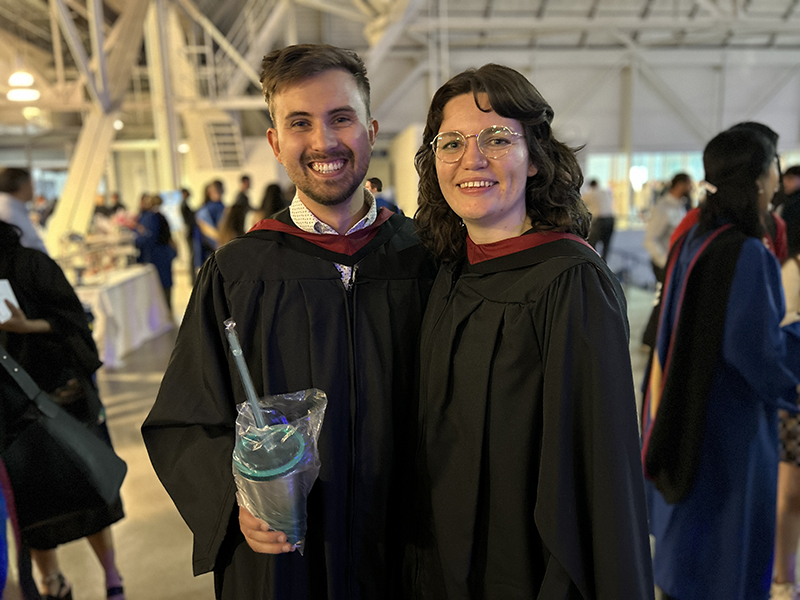 Two School of Journalism 2023 Master graduates stand together.