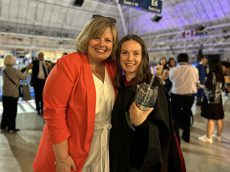 A School of Journalism 2023 Masters graduate poses with News Media Production Specialist Angela Glover.