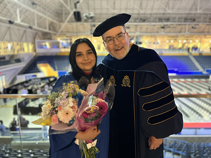 School of Journalism 2023 graduate stands with Dr. Gary  Gould at convocation.