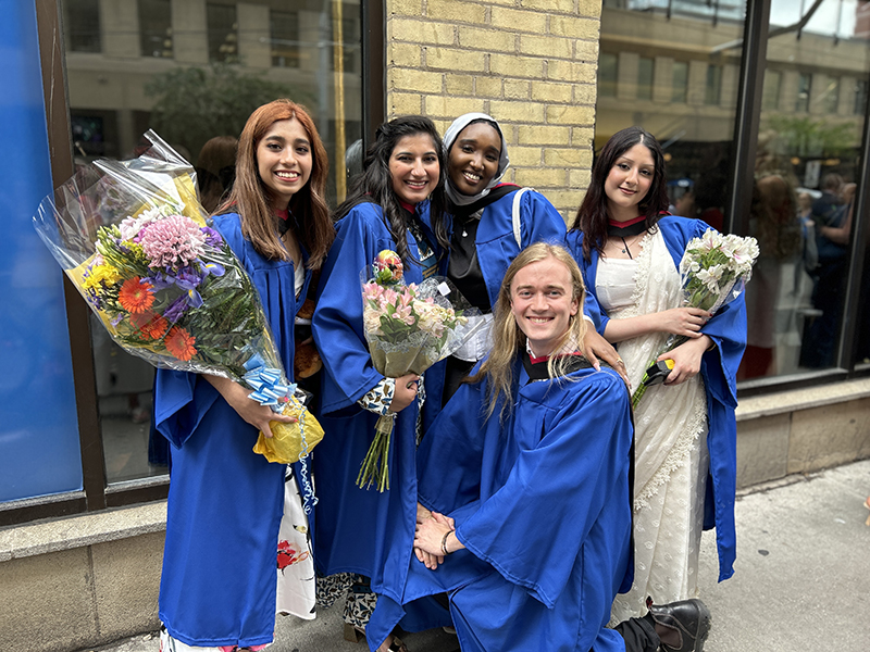 A group of School of Journalism 2023 graduates stand together outside the Mattamy Atheltic Centre.