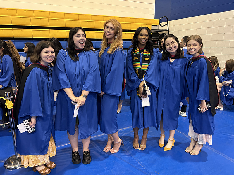 A group of School of Journalism 2023 graduates stand together before the convocation ceremony.