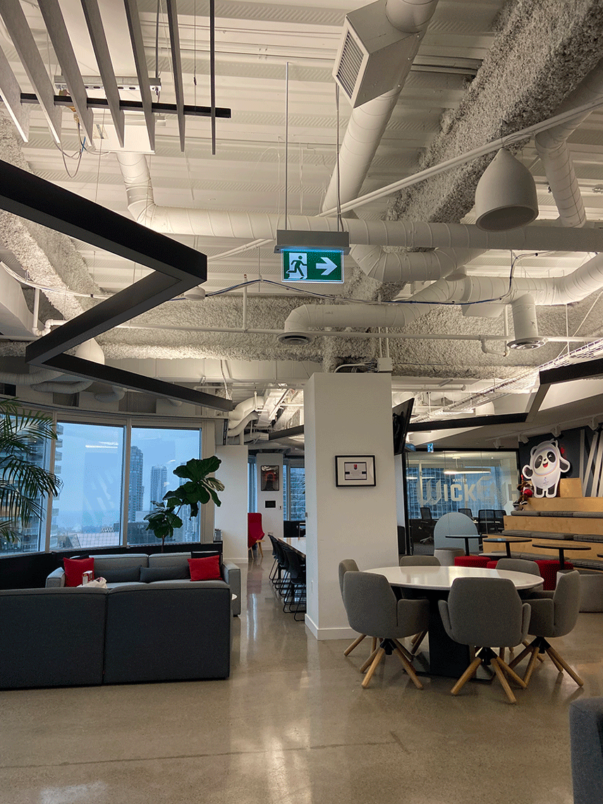An open concept office with a couch and table with chairs