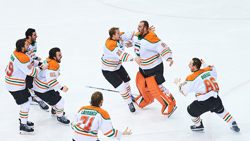 A hockey team celebrates on ice.