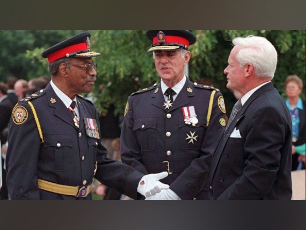 The Honourable Lincoln Alexander dressed with military attire and two men