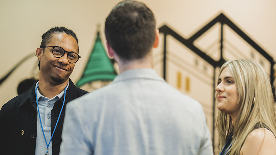 man smiling at colleagues in a crowd at awards ceremony
