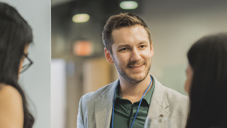 man talking to two women at awards celebration